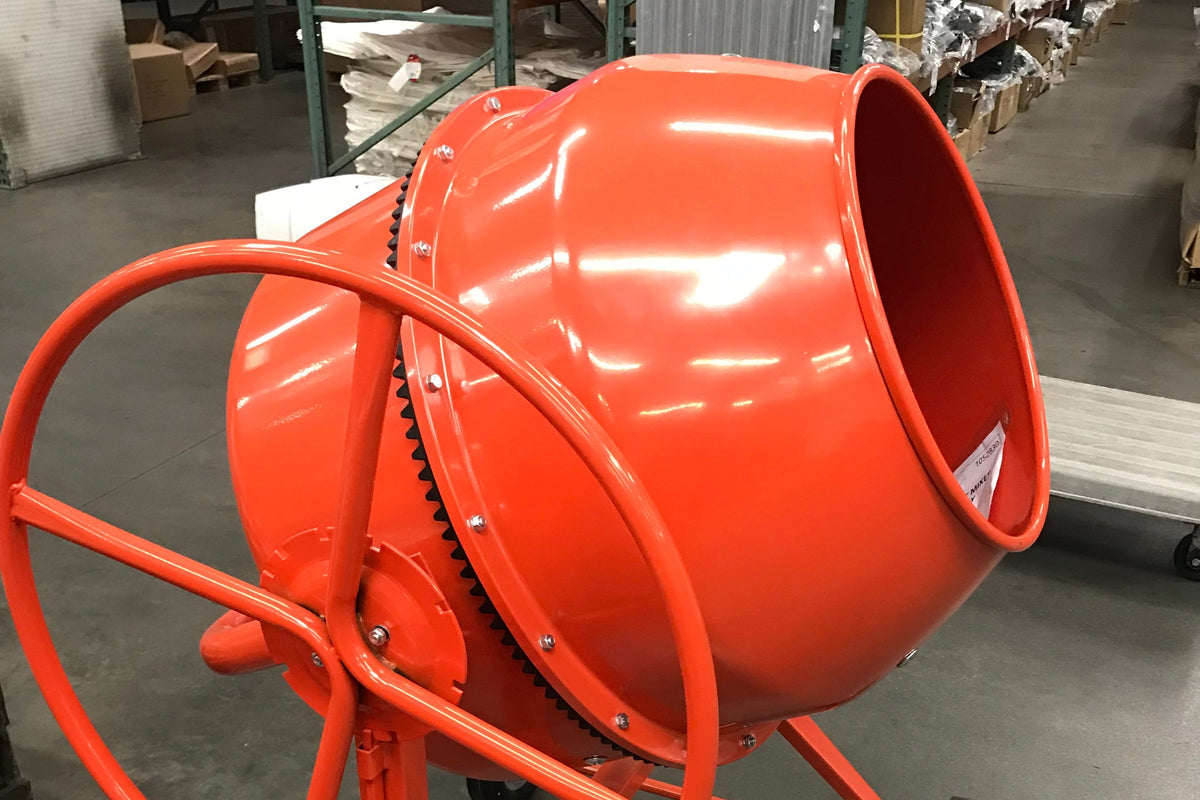 An orange concrete mixer drum on a wheeled stand